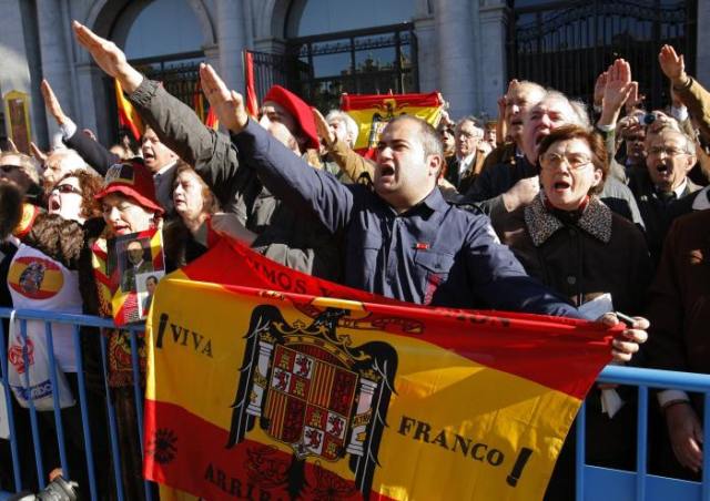 Supporters of Spain's late dictator Francisco Franco raise their arms in a fascist salute during a gathering in Madrid
